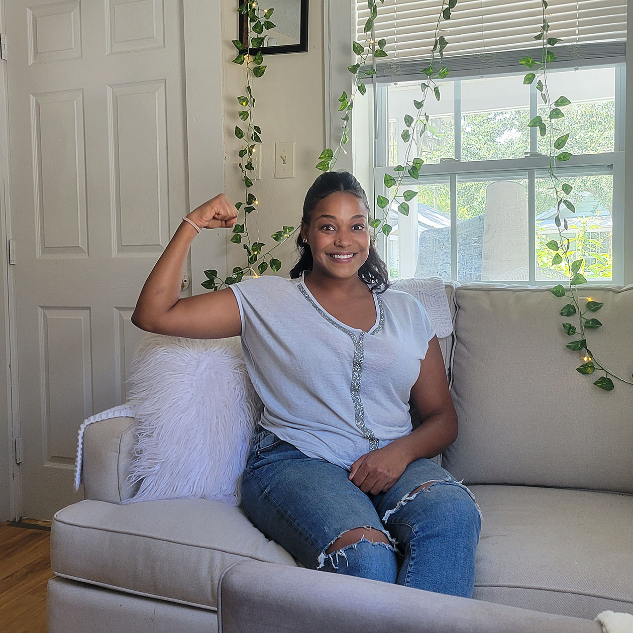 Safae flexing her arm muscle to show the strength she's demonstrated in acquiring permanent housing
